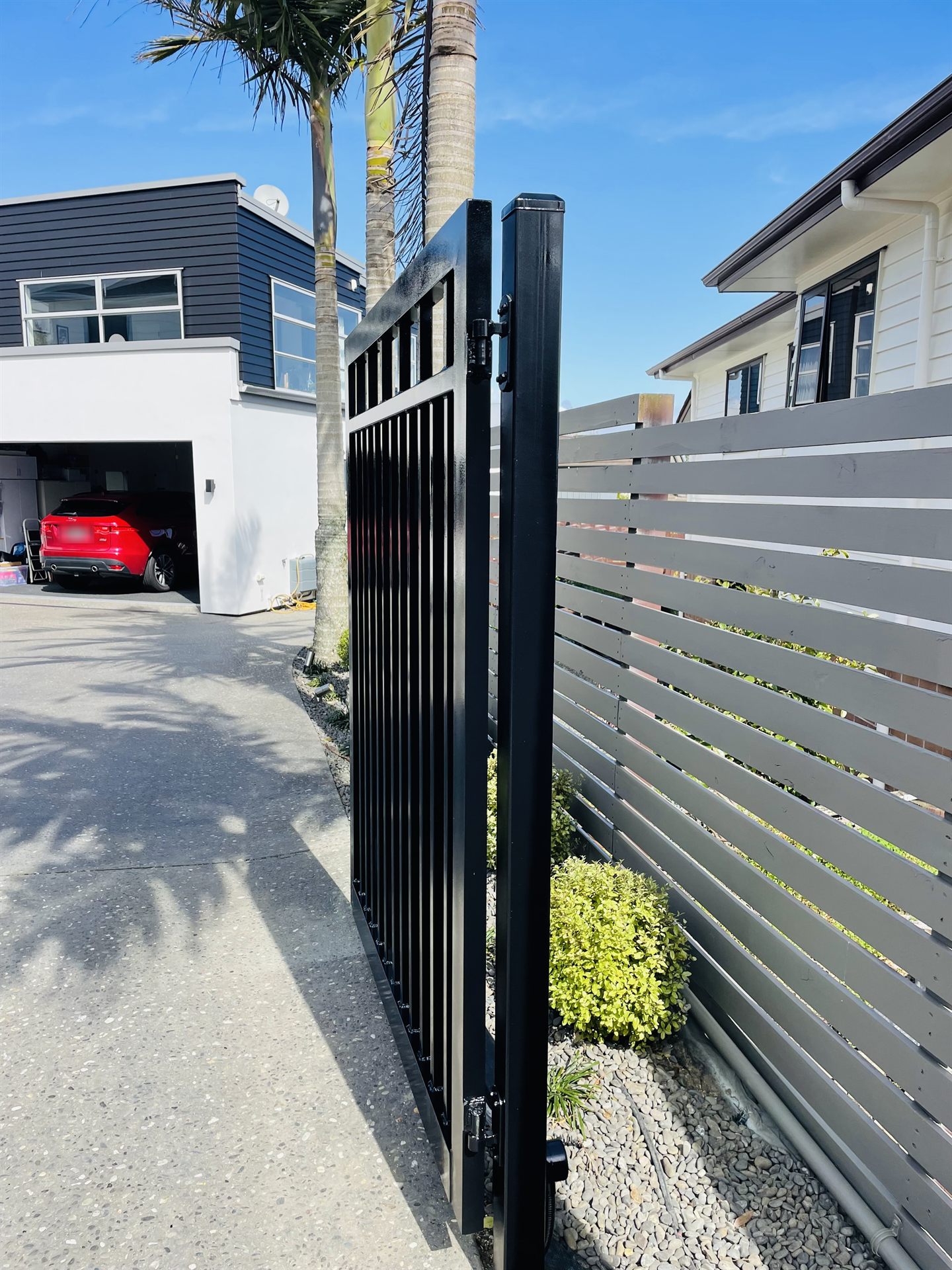 Automatic gate and fence line running alongside a driveway