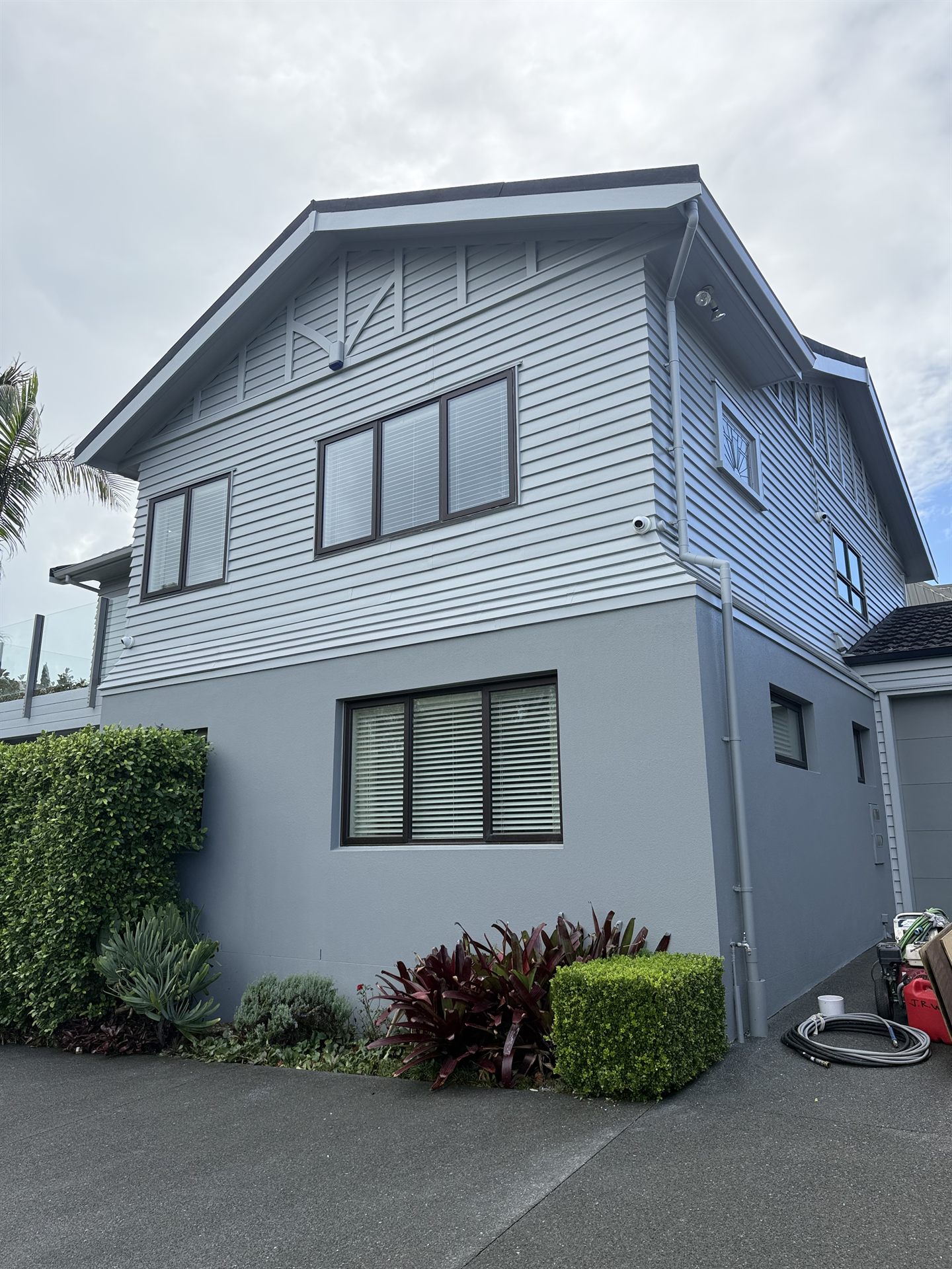 Side elevation showing repainted weatherboards and rendered walls