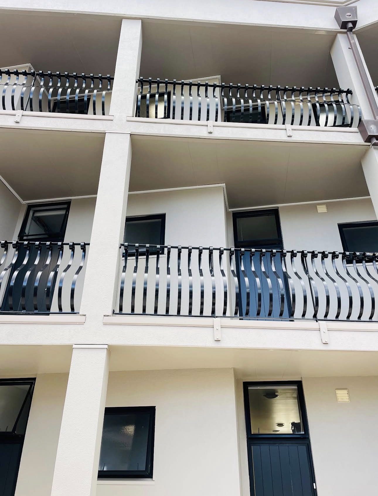 Close view of repainted balcony soffits and gloss black wrought-iron balustrades