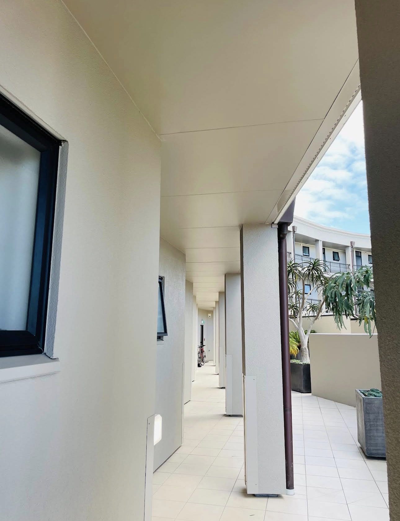 Freshly painted covered walkway running along an apartment floor