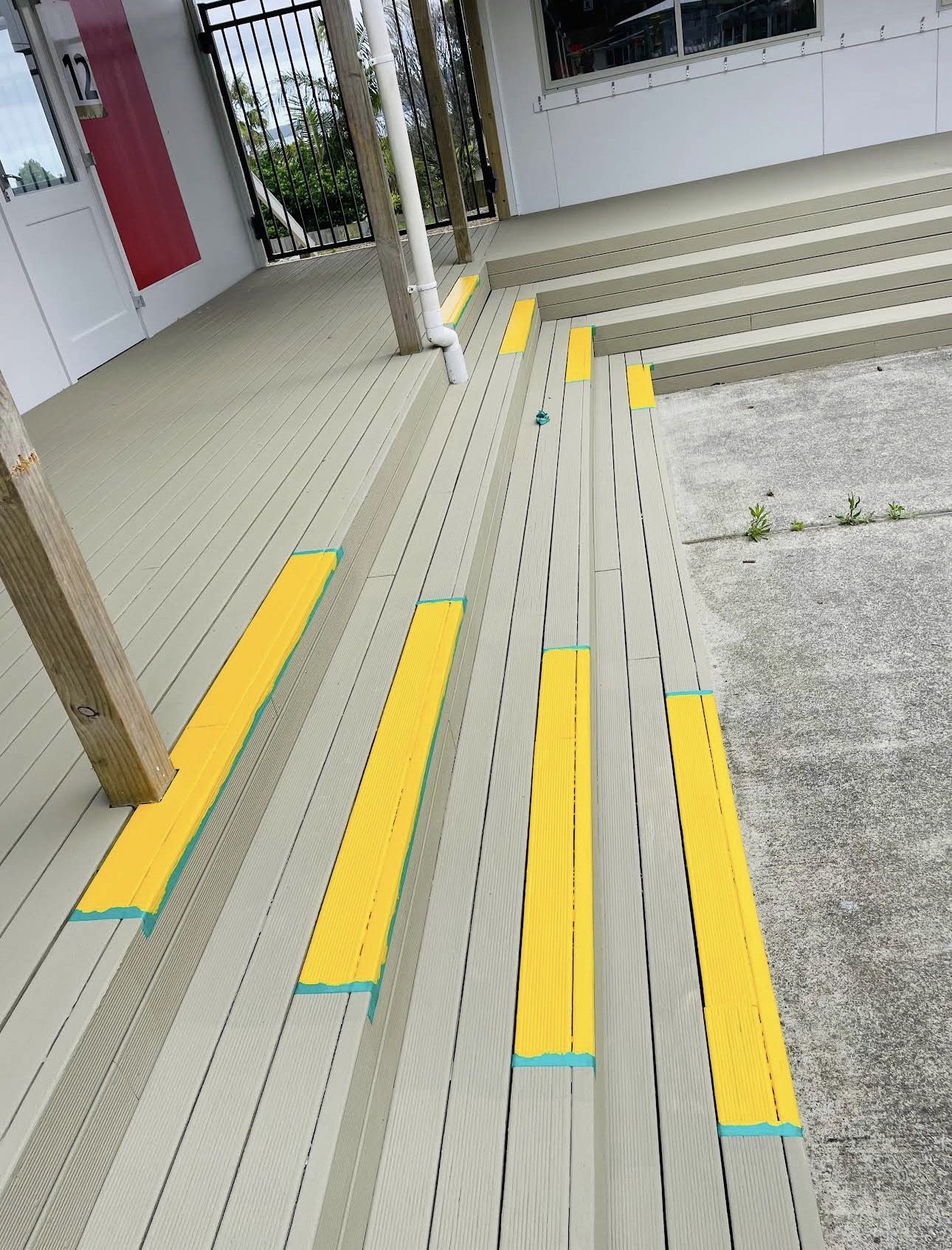 Yellow safety markings masked off and freshly applied to deck steps and a level change